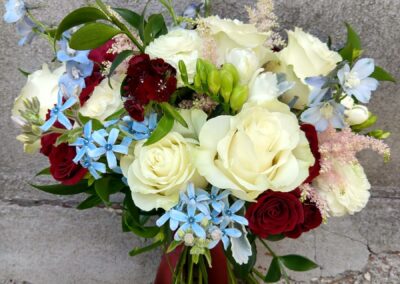 bridal bouquet of white, ivory, blush, blue, and burgundy flowers