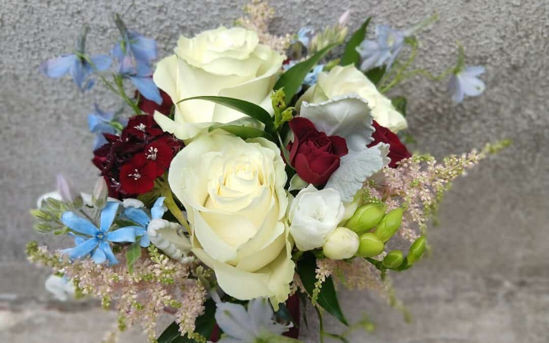 bridesmaid bouquet with white, ivory, blush, blue, and burgundy flowers