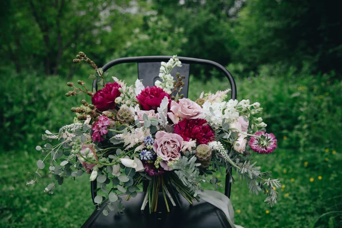 wedding bouquet displayed on a black metal chair
